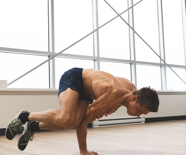 Man performing a controlled strength exercise in a calm studio environment.